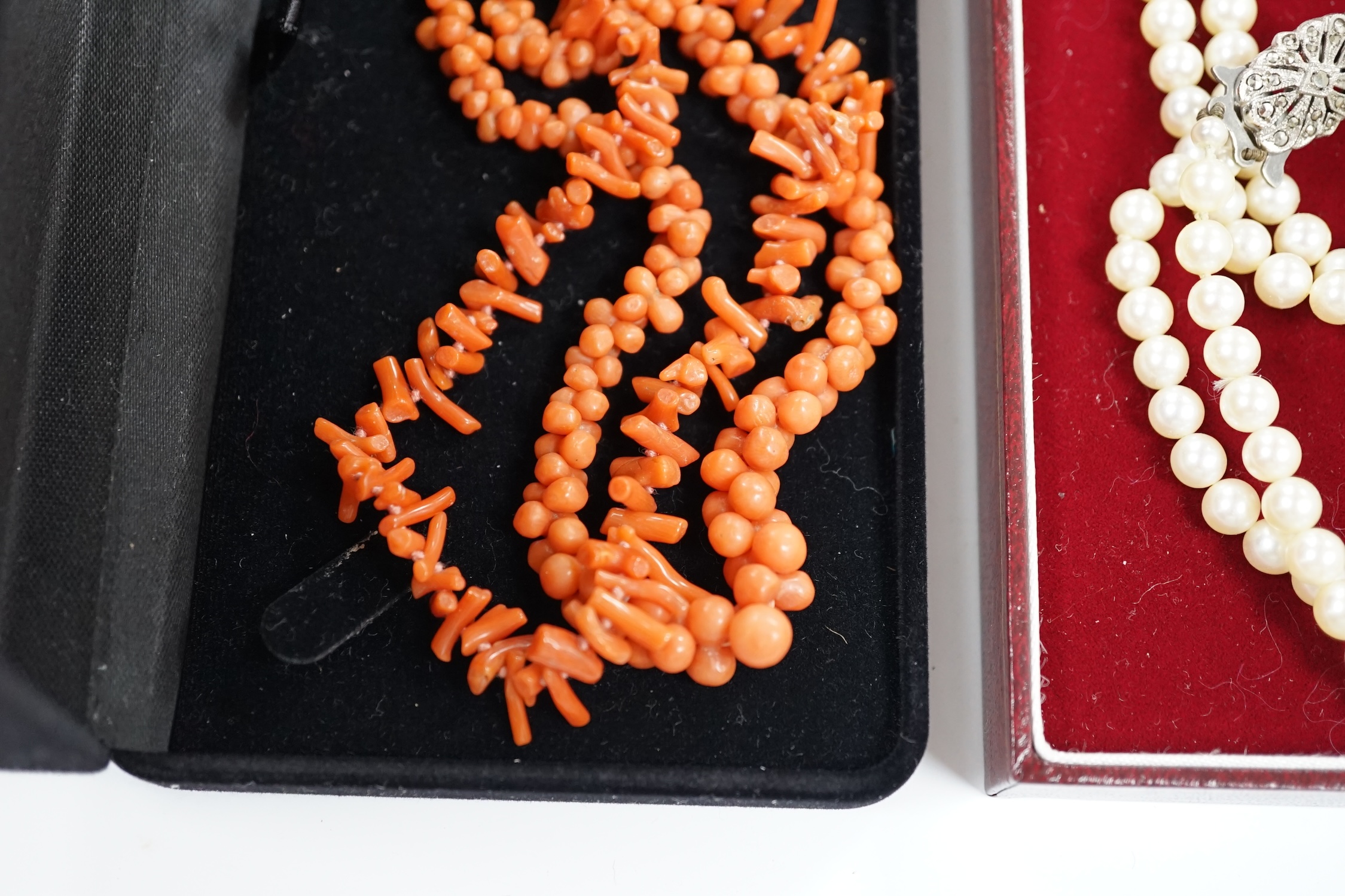 Two coral necklaces, one with beads the other branches, 33cm and a double strand cultured pearl necklace, with marcasite set clasp.